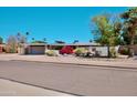 Single story home featuring desert landscaping, including colorful bougainvillea, with a two car garage at 11035 N 37Th St, Phoenix, AZ 85028