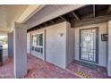 Covered front porch with decorative front door, brick floor and beam accents at 11035 N 37Th St, Phoenix, AZ 85028