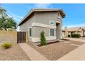 Side view of the home with pavers, stone landscaping and a wooden gate at 1138 E Liberty Shores Dr, Gilbert, AZ 85234