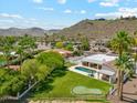 Expansive backyard featuring a lush lawn, putting green, pool, and covered patio area at 14401 N Coral Gables Dr, Phoenix, AZ 85023