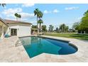 Refreshing pool with travertine tile surround, ladder entry and view of backyard landscaping at 14401 N Coral Gables Dr, Phoenix, AZ 85023