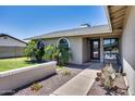 Inviting entrance with a neat garden, a sitting bench, and a clear pathway to the front door at 18642 N 13Th Ave, Phoenix, AZ 85027