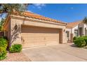 Close up of two car garage with low shrubbery along the front and gravel on the side at 221 N Ironwood St, Gilbert, AZ 85234