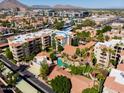 Stunning aerial view of condo complex with community pool, mature trees, and beautiful desert landscaping at 4200 N Miller Rd # 503, Scottsdale, AZ 85251