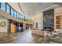 Open-concept living room with fireplace, modern decor, and floor-to-ceiling curved windows at 43105 N 102Nd St, Scottsdale, AZ 85262