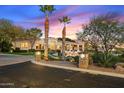 Elegant home with palm trees, manicured lawn, and a circular driveway at sunset at 6621 N Arizona Biltmore Cir, Phoenix, AZ 85016