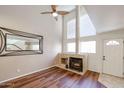 Cozy living room featuring a fireplace, high ceilings, and bright windows at 10 E Betty Elyse Ln, Phoenix, AZ 85022