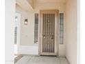 Covered porch and front door with wrought iron security door and desert landscaping at 1024 W Ayrshire Trl, San Tan Valley, AZ 85143