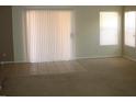 Bright living room with carpet and tile flooring, sliding glass doors, and natural light at 11218 W Glenrosa Ave, Phoenix, AZ 85037