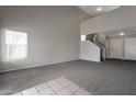 Open living room boasts neutral paint, plush carpet and a vaulted ceiling at 11218 W Glenrosa Ave, Phoenix, AZ 85037