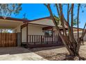 Front exterior featuring a covered porch, carport, and desert landscaping at 115 S Stardust Ln, Apache Junction, AZ 85120