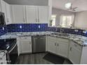 Modern kitchen featuring stainless steel appliances, granite countertops, and a blue tile backsplash at 11760 N 153Rd Ave, Surprise, AZ 85379