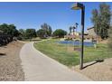 Community walking path with green spaces, palm trees, and blue basketball court at 11760 N 153Rd Ave, Surprise, AZ 85379