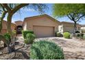Charming home exterior with a neutral color palette, manicured landscaping, and a brick driveway leading to a two-car garage at 12946 N Northstar Dr, Fountain Hills, AZ 85268