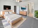 Inviting bedroom with soft carpet, mounted televisions, and neutral decor at 14154 W Voltaire St, Surprise, AZ 85379