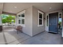 Inviting covered patio featuring a cozy bench and view of the landscaped front yard at 14770 W Voltaire St, Surprise, AZ 85379