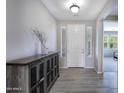 Bright foyer featuring wood-look tile flooring, modern lighting, and a decorative console table at 14770 W Voltaire St, Surprise, AZ 85379