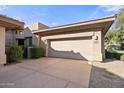 Attached two-car garage featuring a neutral-colored door and concrete driveway at 15240 N Clubgate Dr # 137, Scottsdale, AZ 85254