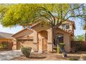 Charming residence featuring a two-car garage and arched entryway, enhanced by mature landscaping at 15432 W Yucatan Dr, Surprise, AZ 85379