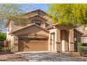 Inviting home showcasing a two-car garage and covered front entry, framed by desert landscaping at 15432 W Yucatan Dr, Surprise, AZ 85379