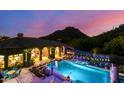 Night view of the backyard pool with lights and mountain views in the distance at 16469 N 113Th Way, Scottsdale, AZ 85255