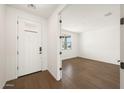 Bright entryway featuring wood flooring, a white front door, and an open doorway at 17250 W Via Dona Rd, Surprise, AZ 85387