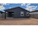 View of the home's rear exterior with a covered patio and spacious dirt backyard at 18256 W La Senda Dr, Surprise, AZ 85387