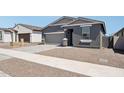 Attractive single-Gathering home features a gray exterior, two-car garage, and gravel landscaping for a low-maintenance yard at 18256 W La Senda Dr, Surprise, AZ 85387