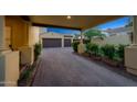 Paver driveway leading to a three-car garage, surrounded by manicured landscaping at 20791 W Main St, Buckeye, AZ 85396