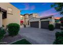 View of home's two-car garage and circular turret-style entryway with brick-paved driveway at 20791 W Main St, Buckeye, AZ 85396