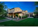 Beautiful two-story home with a tile roof, covered porch, and well-manicured lawn and landscaping at 20791 W Main St, Buckeye, AZ 85396