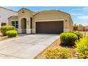 Inviting single-story home featuring a well-maintained yard, a dark front door and attached garage at 28259 N Chalcocite St, San Tan Valley, AZ 85143