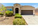 Inviting single-story home featuring a well-maintained yard, a dark front door and attached garage at 28259 N Chalcocite St, San Tan Valley, AZ 85143