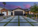 Modern driveway with concrete pavers separated by grass, leading to an attached garage at 3425 N 50Th Pl, Phoenix, AZ 85018