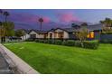 Expansive home exterior with a lush green lawn, mature landscaping, and a gated entrance at 3425 N 50Th Pl, Phoenix, AZ 85018