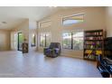 Bright living room features large windows, neutral colors, tile flooring, and comfortable seating arrangements at 3928 N 151St Ave, Goodyear, AZ 85395