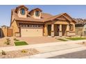 Attractive home features a brick driveway, manicured landscaping, and a two-car garage at 4320 E Bernice St, Gilbert, AZ 85295