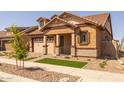 Attractive home features a brick driveway, manicured landscaping, and a covered front porch at 4320 E Bernice St, Gilbert, AZ 85295