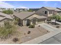 Aerial view of a single-story home with a two-car garage, desert landscaping, and tiled roof at 44284 W Buckhorn Trl, Maricopa, AZ 85138