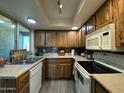 Eat-in kitchen features wooden cabinets and white appliances at 461 W Holmes Ave # 336, Mesa, AZ 85210