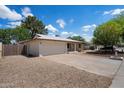 Wide angle view of charming single-story home with spacious driveway and a two-car garage at 4744 W Altadena Ave, Glendale, AZ 85304