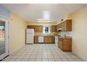 Bright kitchen featuring tile floors, white appliances and views to the backyard at 4744 W Altadena Ave, Glendale, AZ 85304