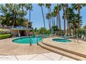 Inviting community pool and spa area surrounded by lush landscaping and palm trees at 5102 N 31St Pl # 436, Phoenix, AZ 85016
