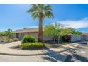 Corner lot home featuring mature landscaping, a palm tree, and a two-car garage at 6333 W Banff Ln, Glendale, AZ 85306
