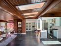 Bright and open living room featuring a skylight, brick accents, and seamless transition to the modern kitchen at 712 W Vernon Ave, Phoenix, AZ 85007