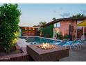 Backyard pool with a fire pit, lounge chairs, and a covered patio, perfect for outdoor entertaining at 712 W Vernon Ave, Phoenix, AZ 85007
