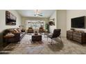 Bright living room with neutral tones, tile flooring, stylish furniture and a ceiling fan for added comfort at 7332 W Pershing Ave, Peoria, AZ 85381