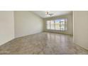 Bright open room with tile flooring, ceiling fan, and large windows looking out to the backyard at 7332 W Pershing Ave, Peoria, AZ 85381