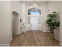 Elegant foyer featuring hardwood floors, shuttered sidelights, a decorative chandelier, and high ceilings at 7425 E Gainey Ranch Rd # 13, Scottsdale, AZ 85258