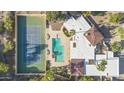 Aerial view showcases the property's pool, tennis court, and unique architectural design with red tile roofs at 7816 N 47Th St, Paradise Valley, AZ 85253